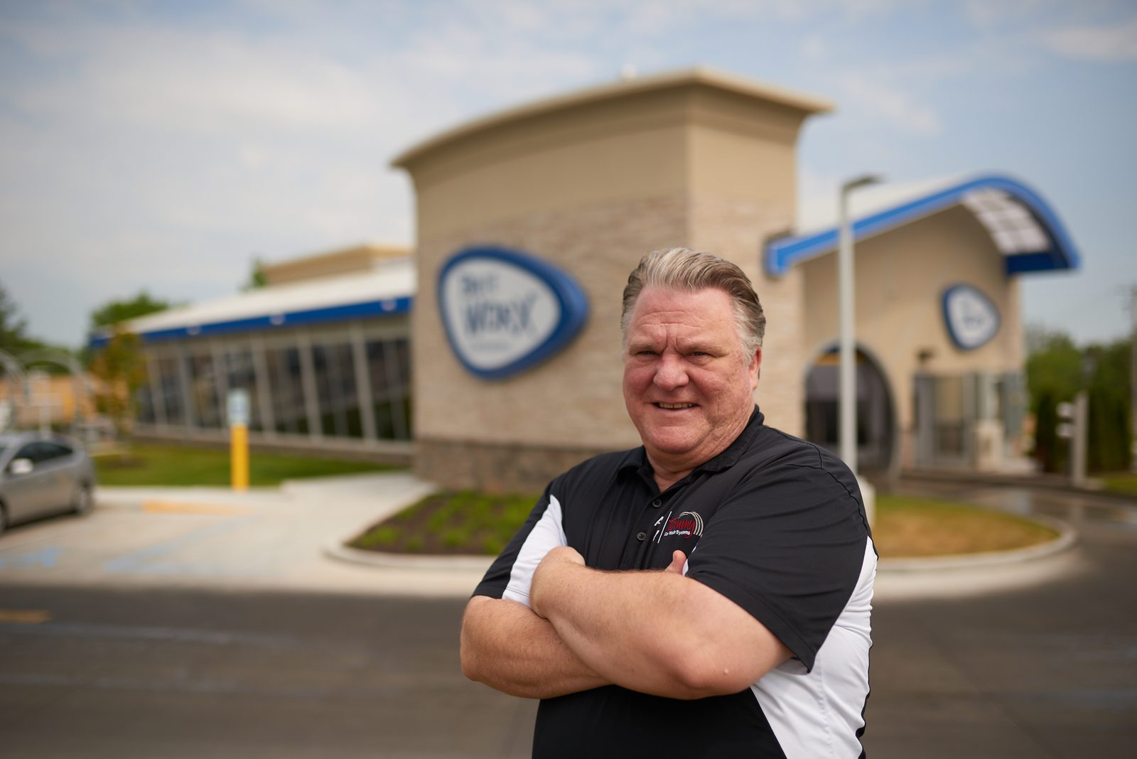 A Brite WorX manager standing outside one of the stores, the blue building and its arch behind him