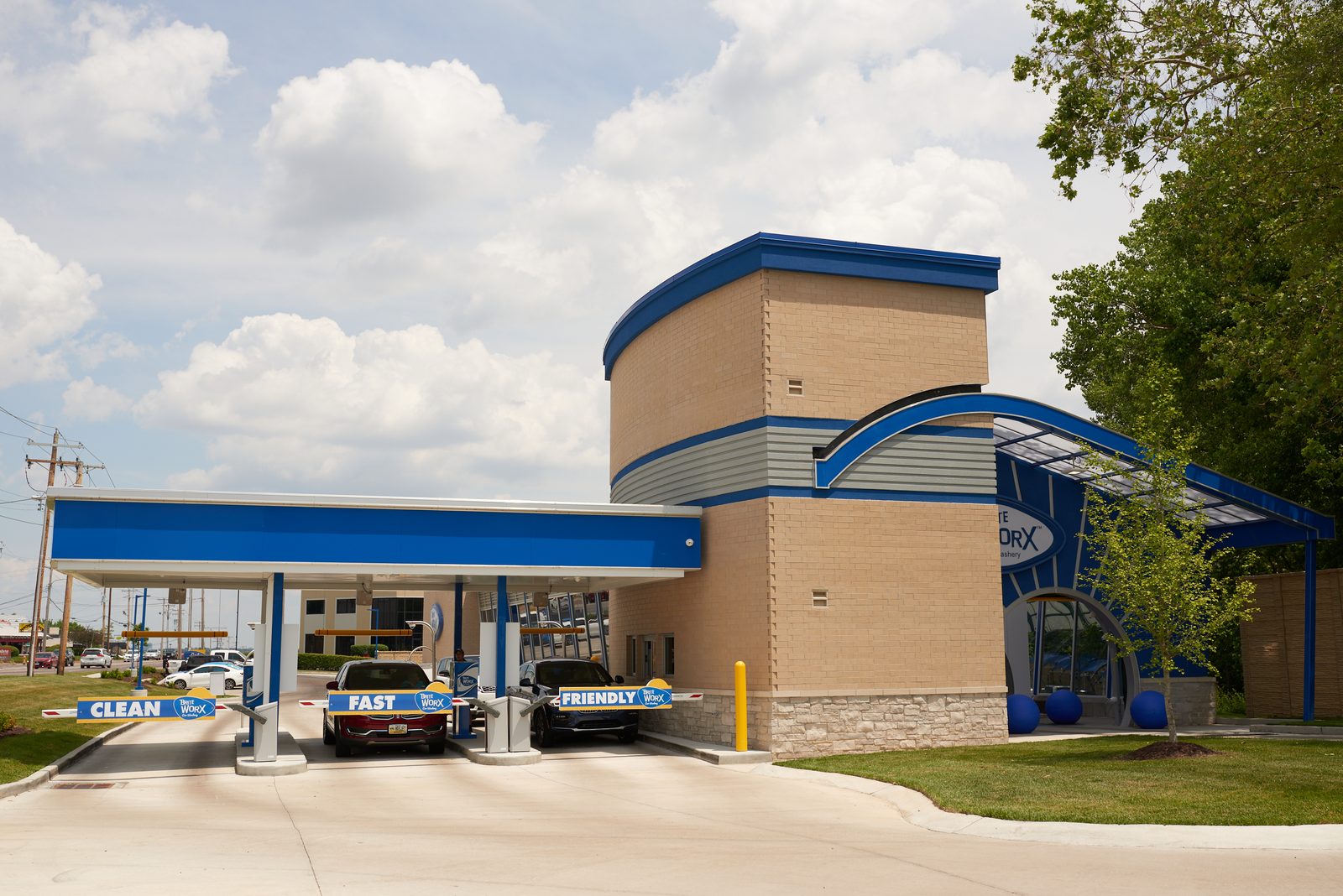 The vacuum canopy at a Brite WorX Car Washery, two cars parked under it beside the FAST and FRIENDLY signs, the building behind